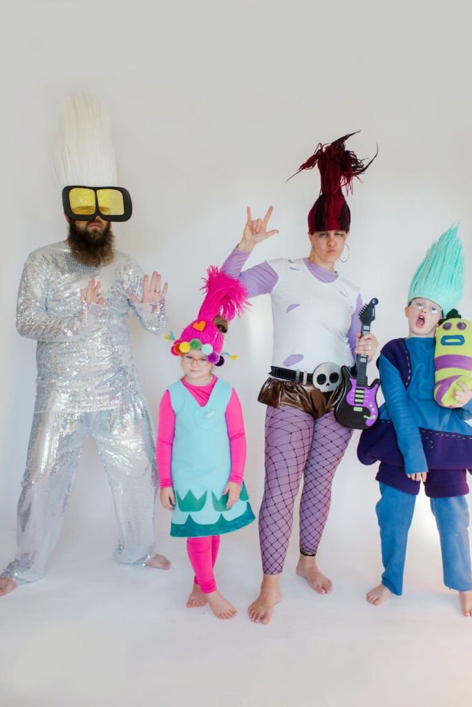 a family tressed in a trolls world tour family halloween costume with poppy, biggie, queen barb and tiny diamond