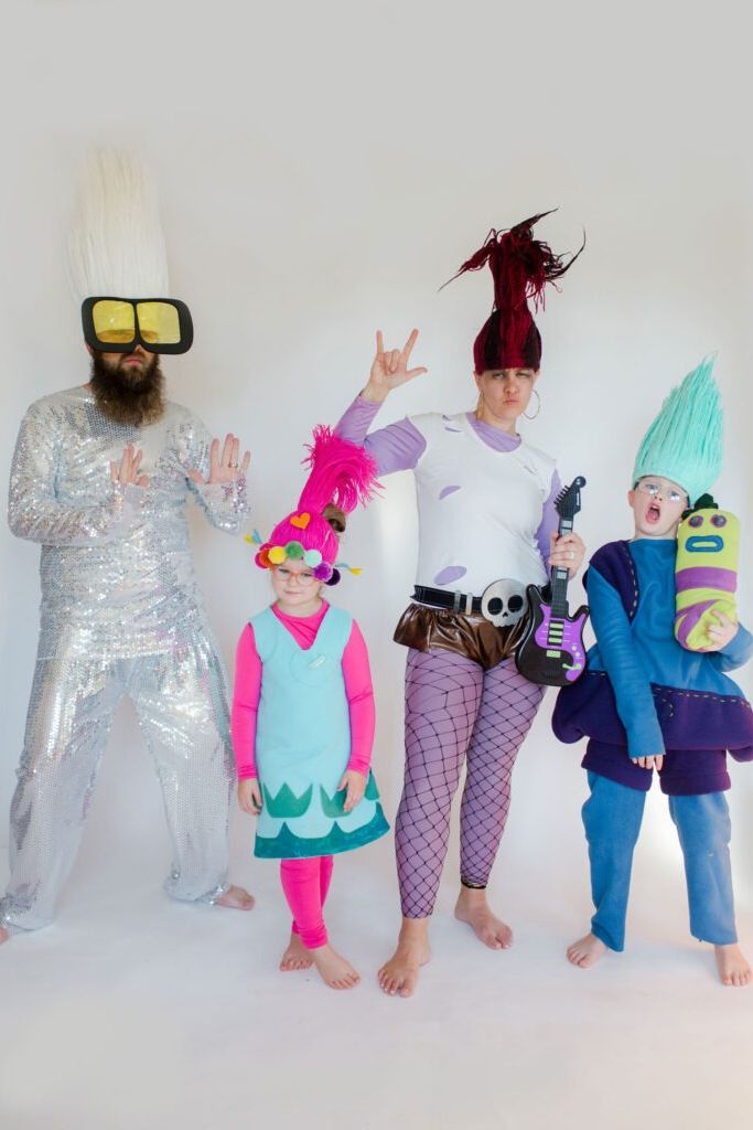 a family tressed in a trolls world tour family halloween costume with poppy, biggie, queen barb and tiny diamond