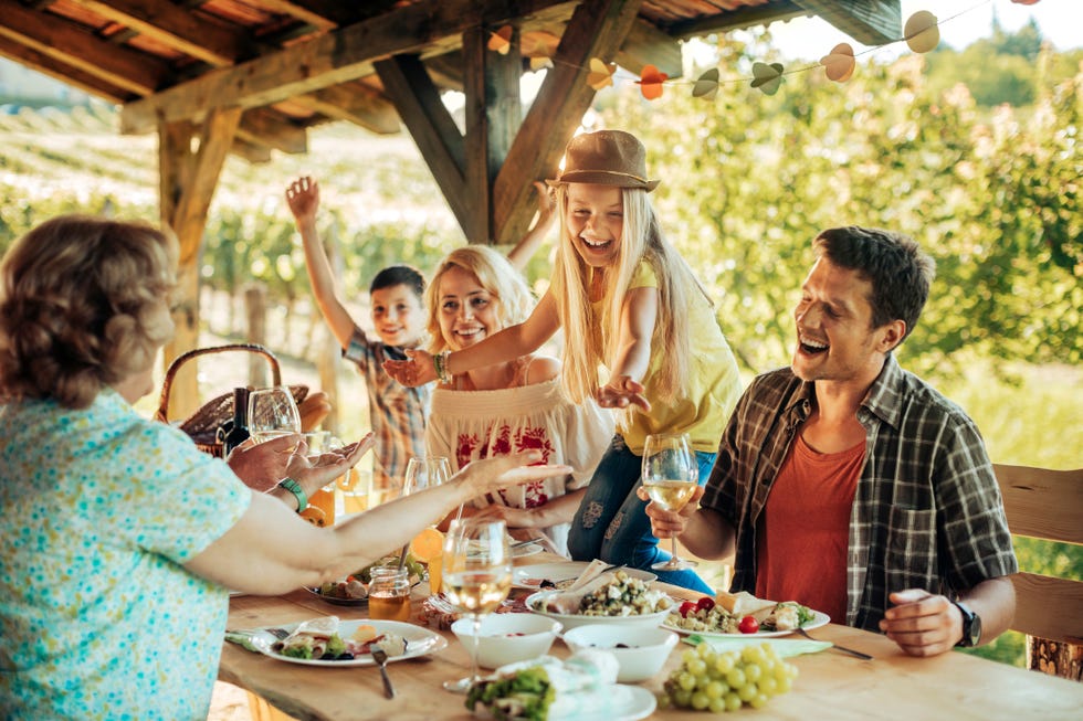 padre, madre y dos hijos disfrutan de una comida en una terraza