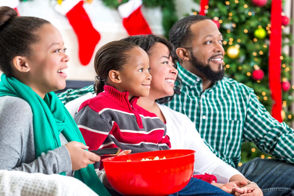 family laughs while watching christmas movie