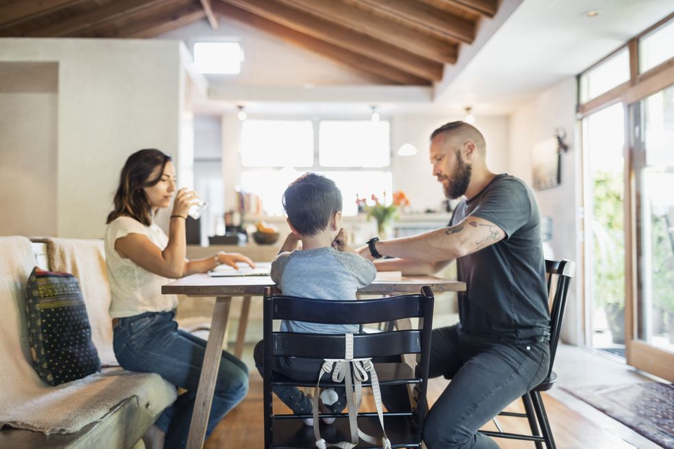 family of three sitting at dining table in house