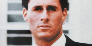 ron goldman looks at the camera, he wears a dark suit jacket, white collared shirt, patterned tie and two hoop earrings in his left ear