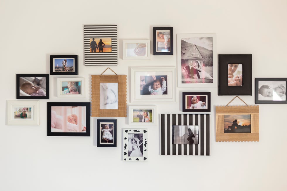 white wall with photos of the family in various photo frames