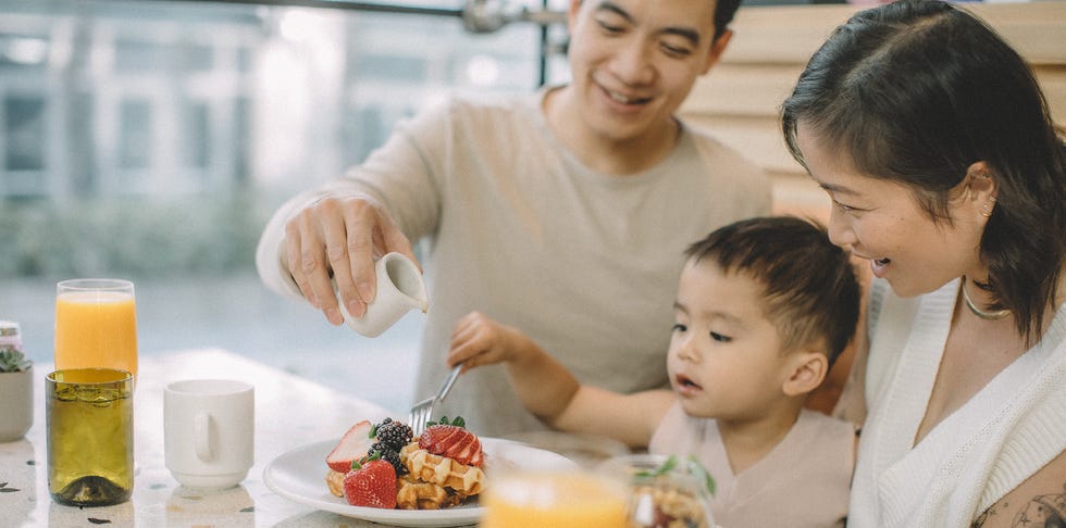 a person and a child eating at a table