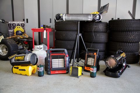 a photograph of all the garage heaters we tested, situated in front of a stack of tires in the road and track garage
