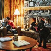 family sitting by fireplace in winter cabin