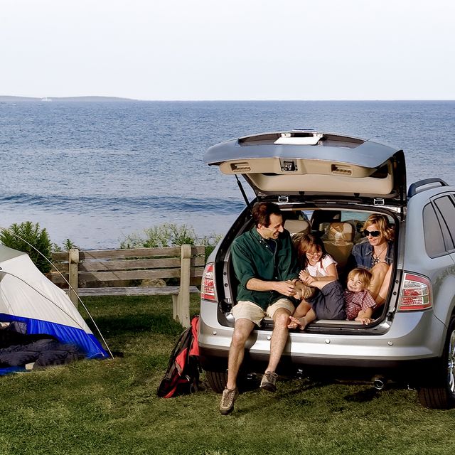 A family sitting in the back of an SUV outdoors