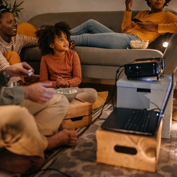 Family sitting together watching movie on projector screen family sitting together watching movie on projector screen