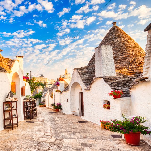 famous trulli houses during a sunny day with bright blue sky in alberobello, puglia, italy