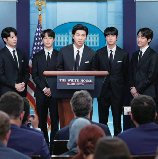 a group of men standing on a stage with a screen behind them