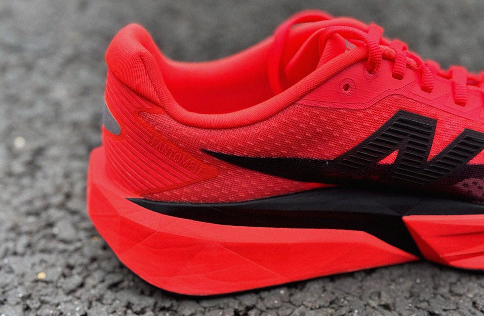 a closeup of a red athletic shoe with a black logo and textured design