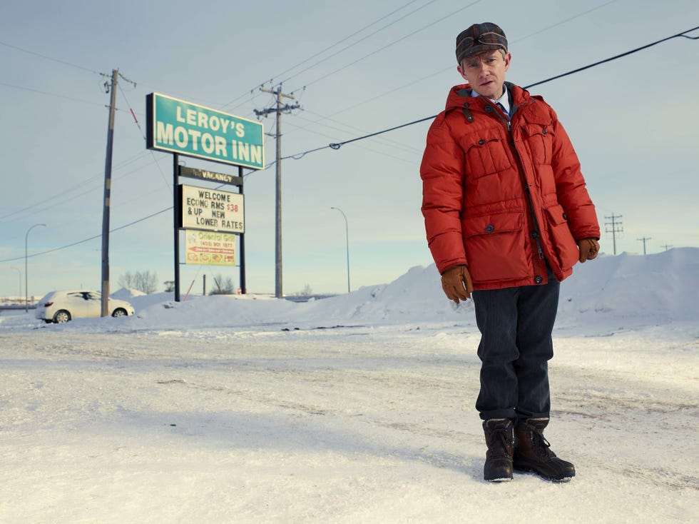 a child standing in a snowy landscape near a motel
