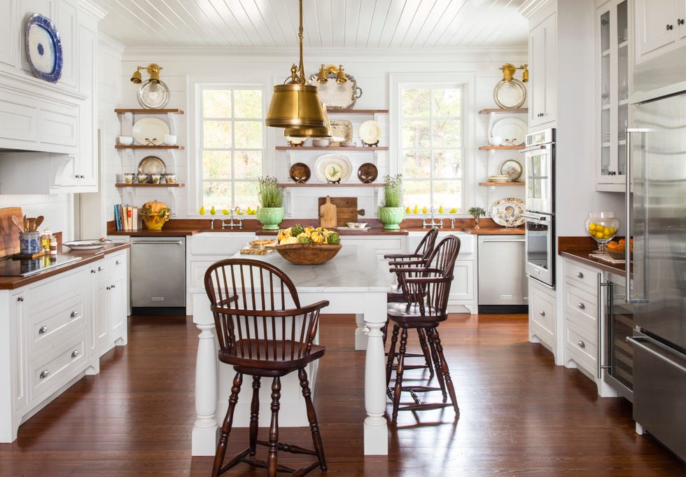 farmhouse kitchen with wood open shelves, big white island and wood windsor style stools