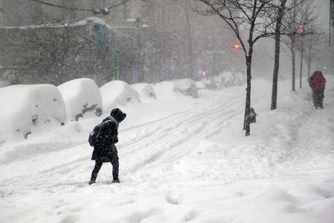 Woman crossing street during snow blizzard Jonas in the Bronx