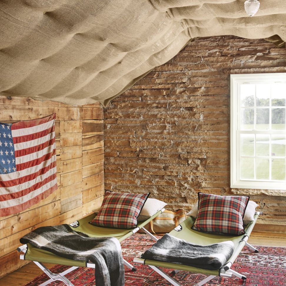 it doesnt get more rustic than walls made from stone quarried on the property and cots outfitted with wool throws and a pair of pillows make for a comfy napping spot