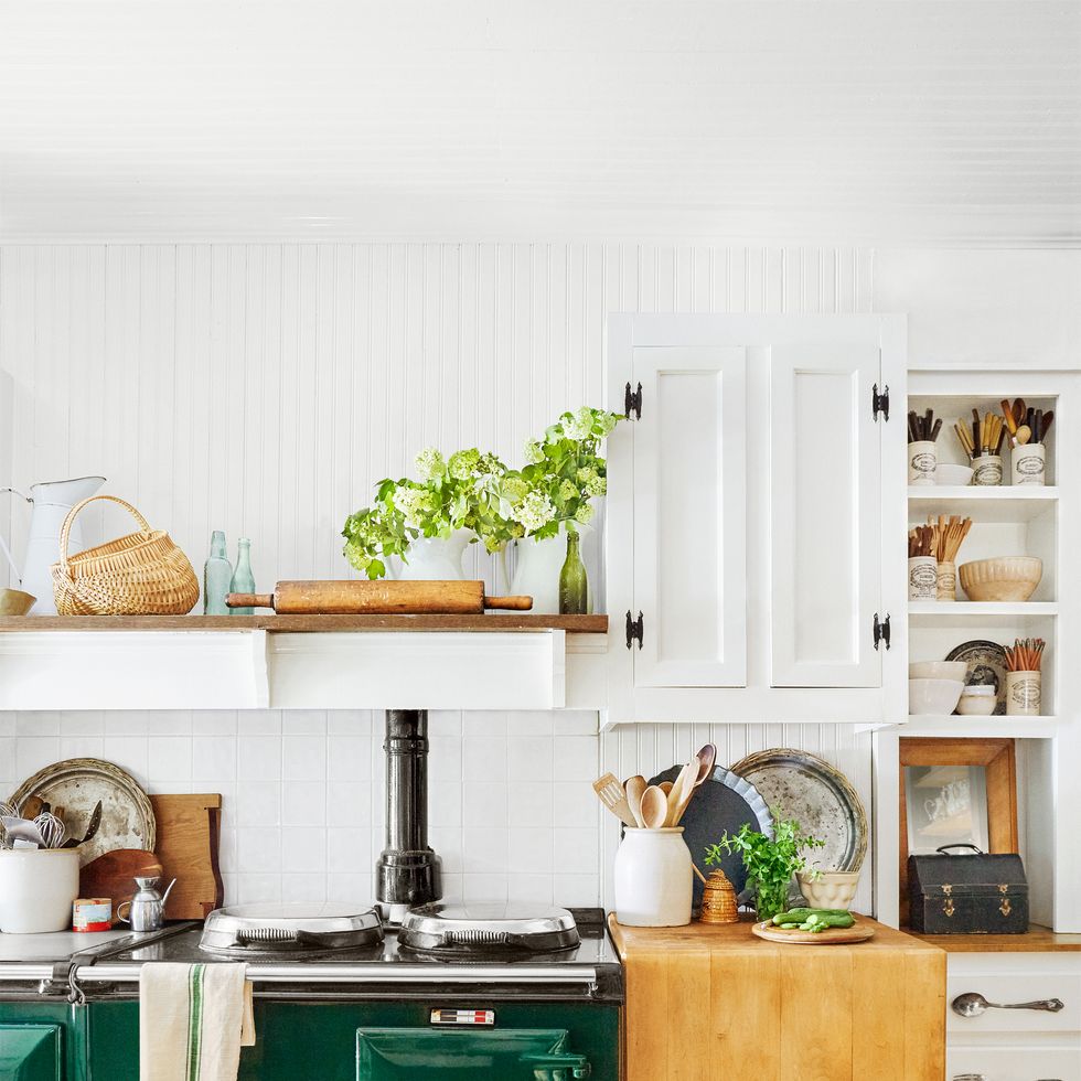 a farmhouse kitchen that has a vintage dark green stove as a focal point