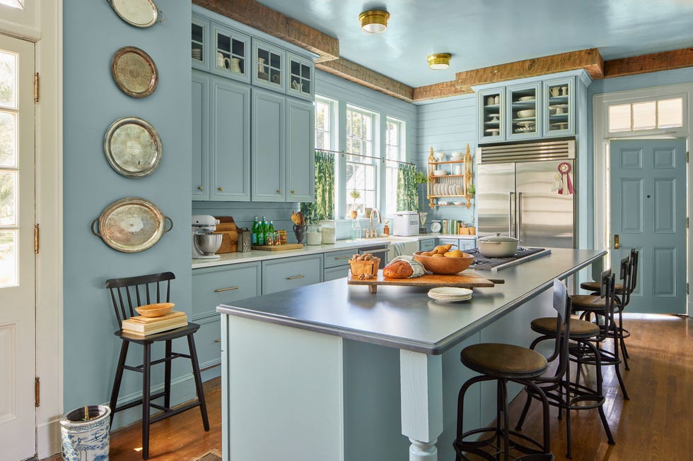 blue farmhouse kitchen with big island and rustic wood ceiling trim