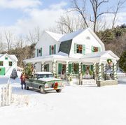 white farmhouse with green shutters and holiday decor