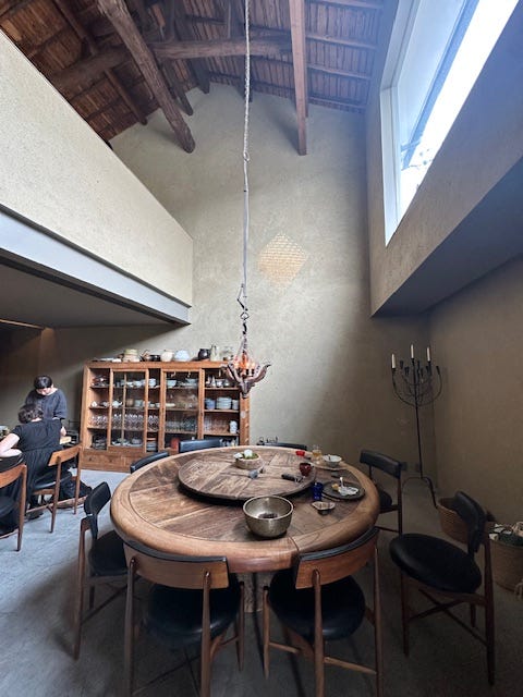 interior dining area with a large round wooden table and a display cabinet