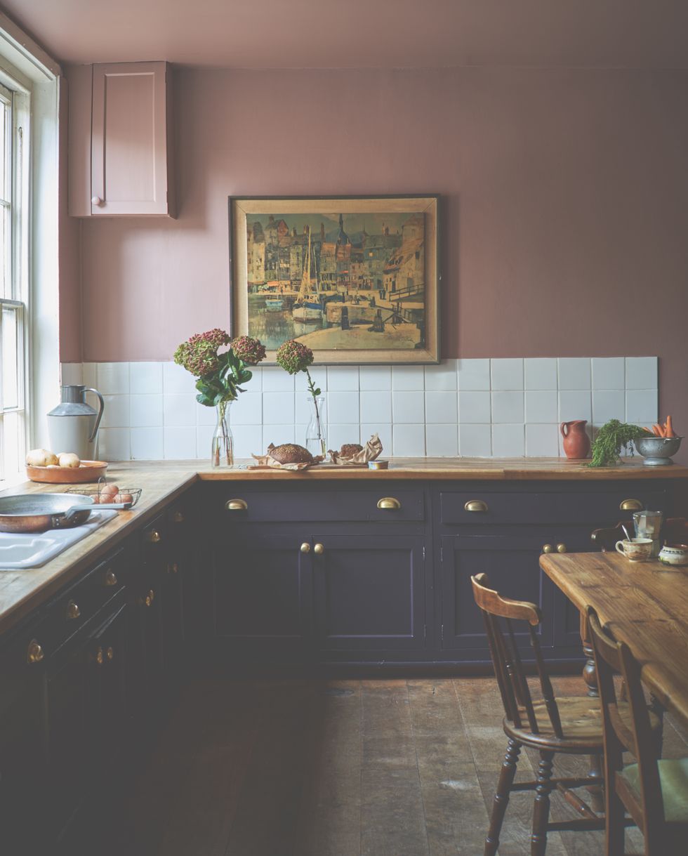 a kitchen painted in farrow ball sulking room pink with navy blue cabinets