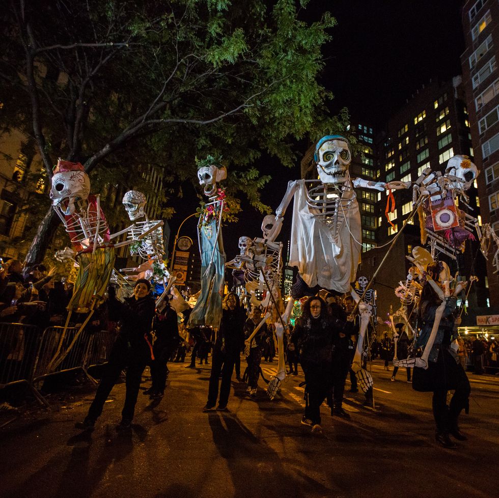 halloween trivia parade with people holding up skeleton decorations