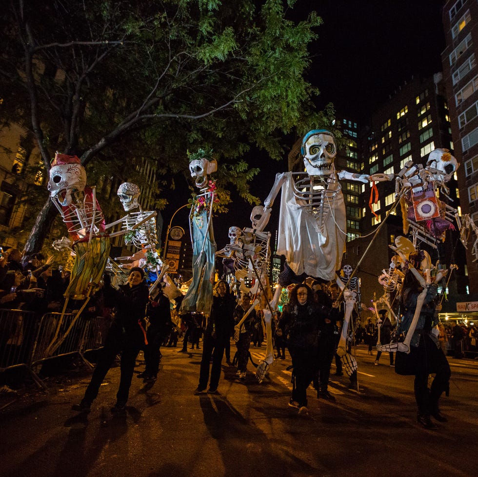 halloween trivia parade with people holding up skeleton decorations