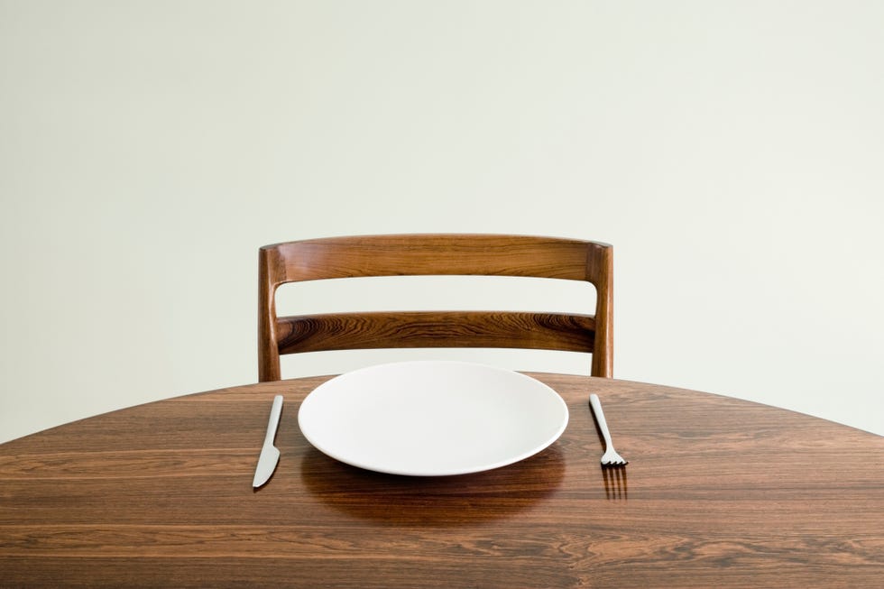 Empty plate with knife and fork on table