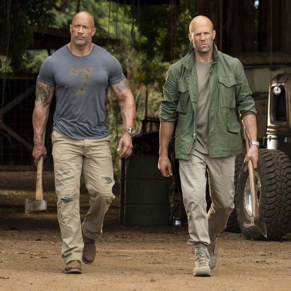 the rock as luke hobbes and jason statham as deckard shaw walk and look tough in a scene from hobbes and shaw