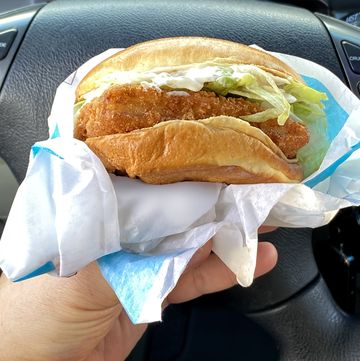 having a fish burger in drive in