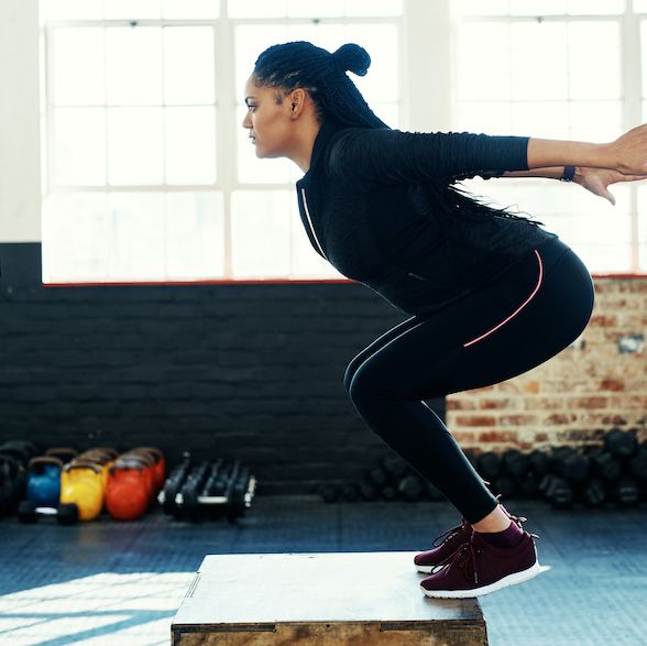fat burning exercises at the gym, shot of a young woman doing a exercise jump on a wooden block in a gym