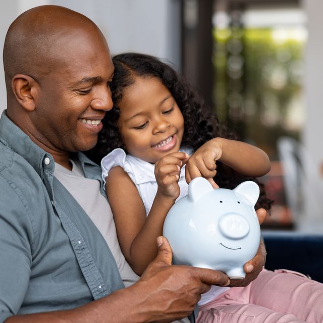 father and daughter saving money in a piggybank