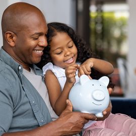 father and daughter saving money in a piggybank