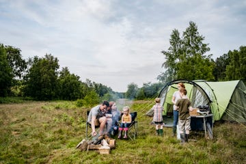 father and mother with children on springtime camping trip