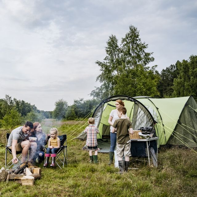 father and mother with children on springtime camping trip