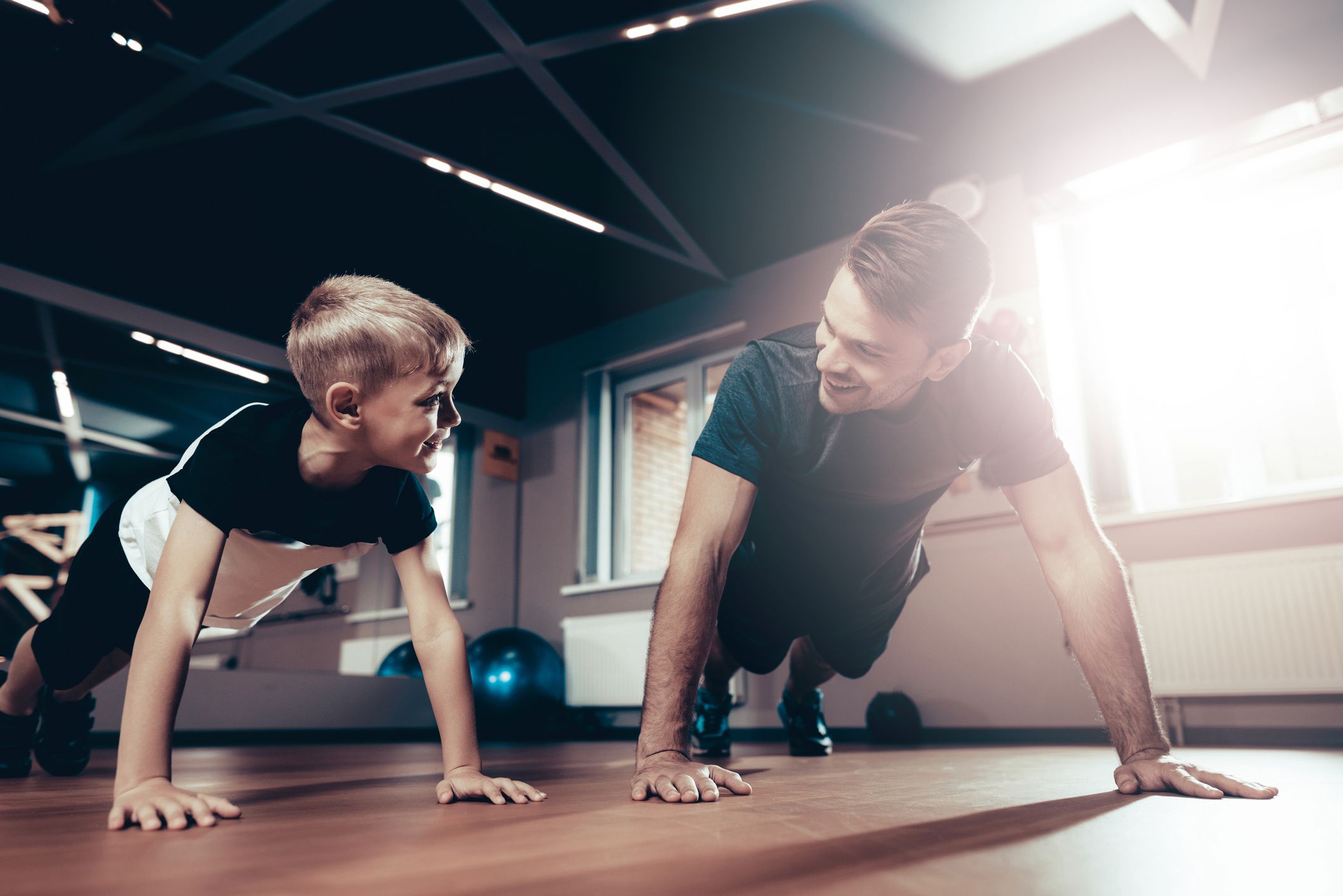 https://hips.hearstapps.com/hmg-prod/images/father-and-son-are-doing-push-ups-in-the-gym-royalty-free-image-1049282158-1557177174.jpg
