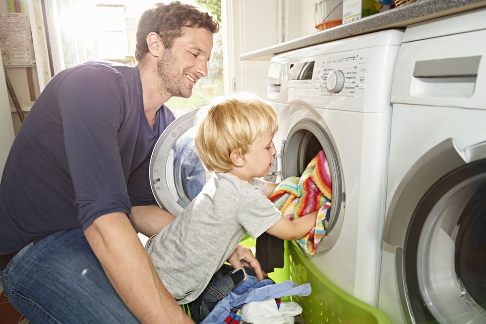 padre e hijo sacan ropa de una lavadora