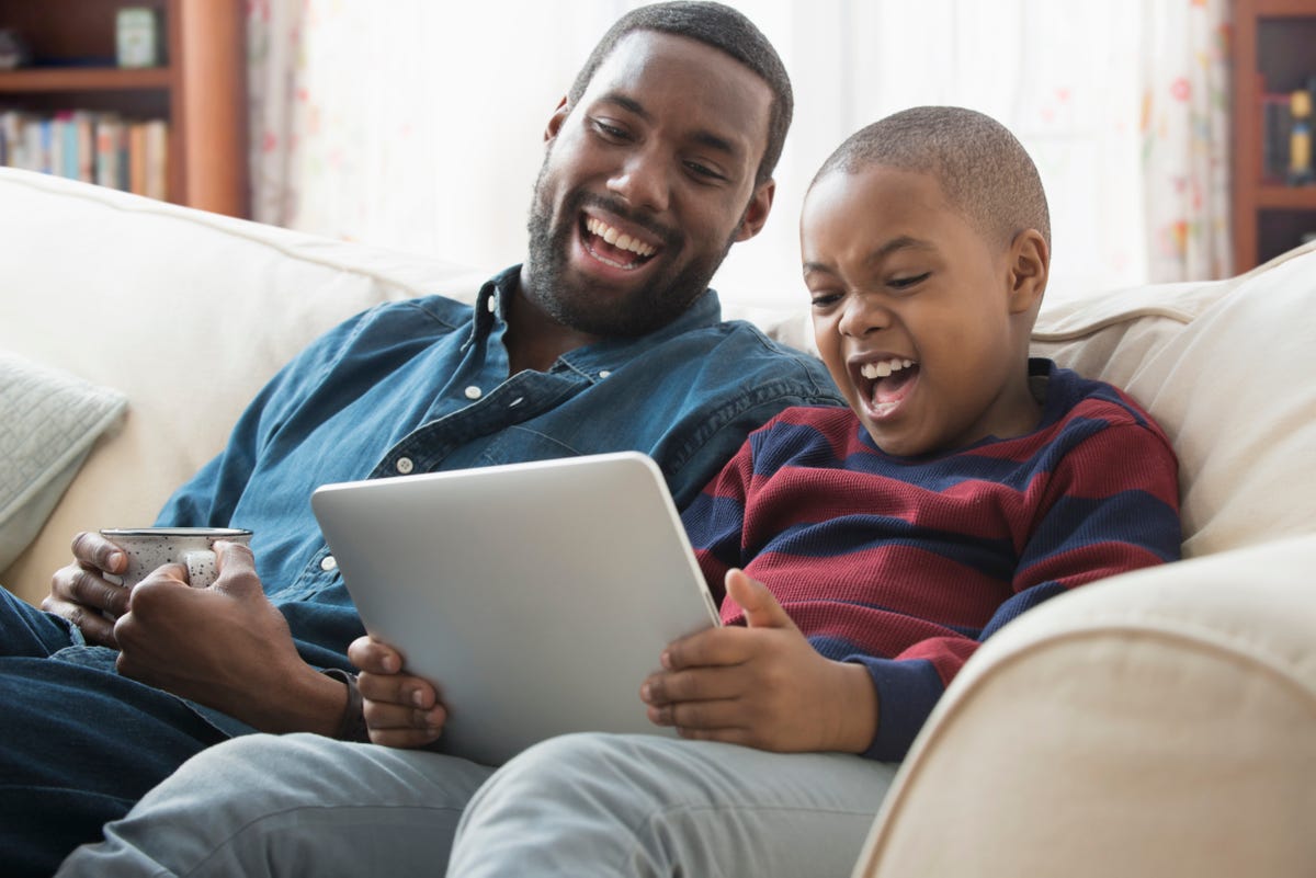 Father and Son Playing Video Games --- Image by © Royalty-…