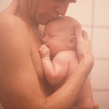 father holding child in shower