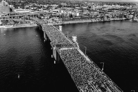 aerial shot of hundreds of people crossing a bridge