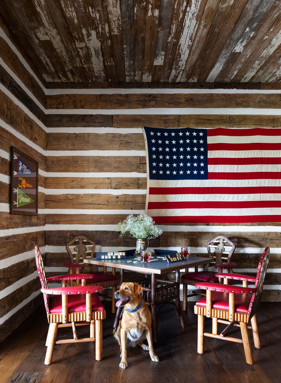 game room leather topped game table surrounded by thomas molesworth inspired chairs american flag hobby ranch and country getaway outside fayetteville, texas homeowners lea ann walker and johnny walker