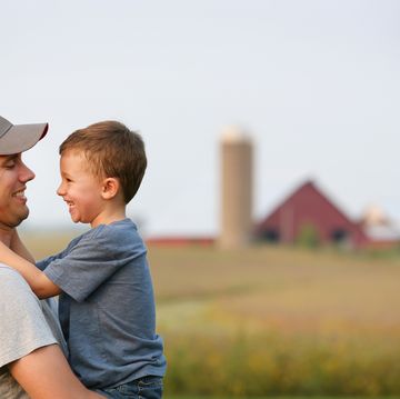 a father and son hug each other on their family farm