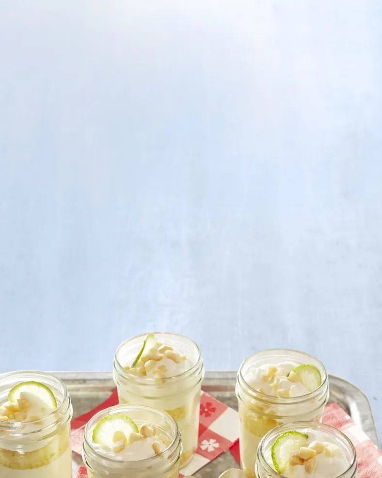 key lime cakes in a jar on metal tray with red napkins and spoons