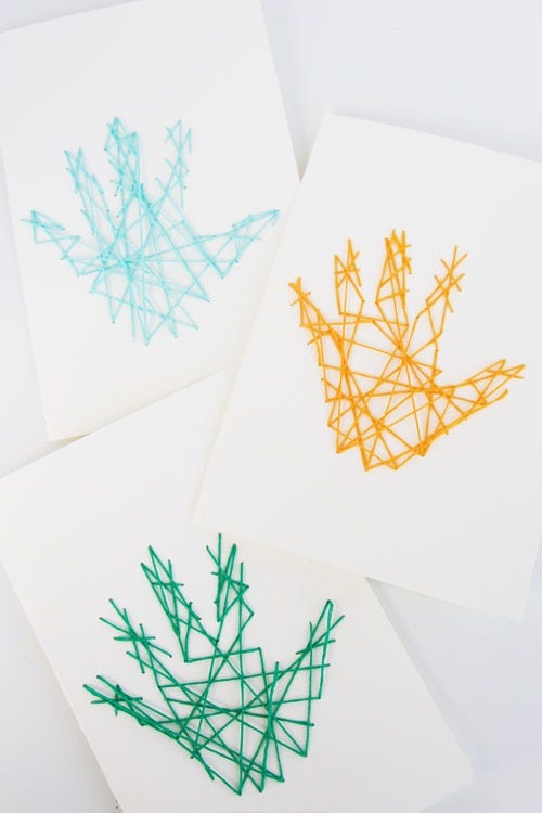 father's day card ideas, white cards with colorful handprint string art on the front