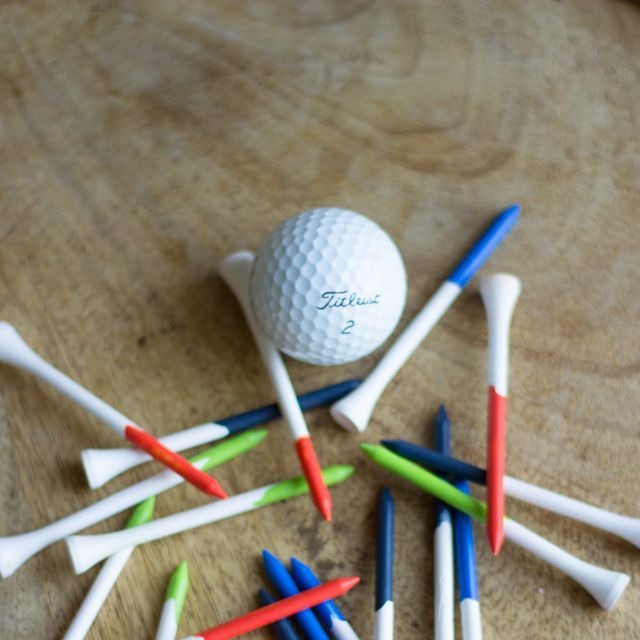 golf ball and tees with ends painted blue, green or orange for a father's day gift
