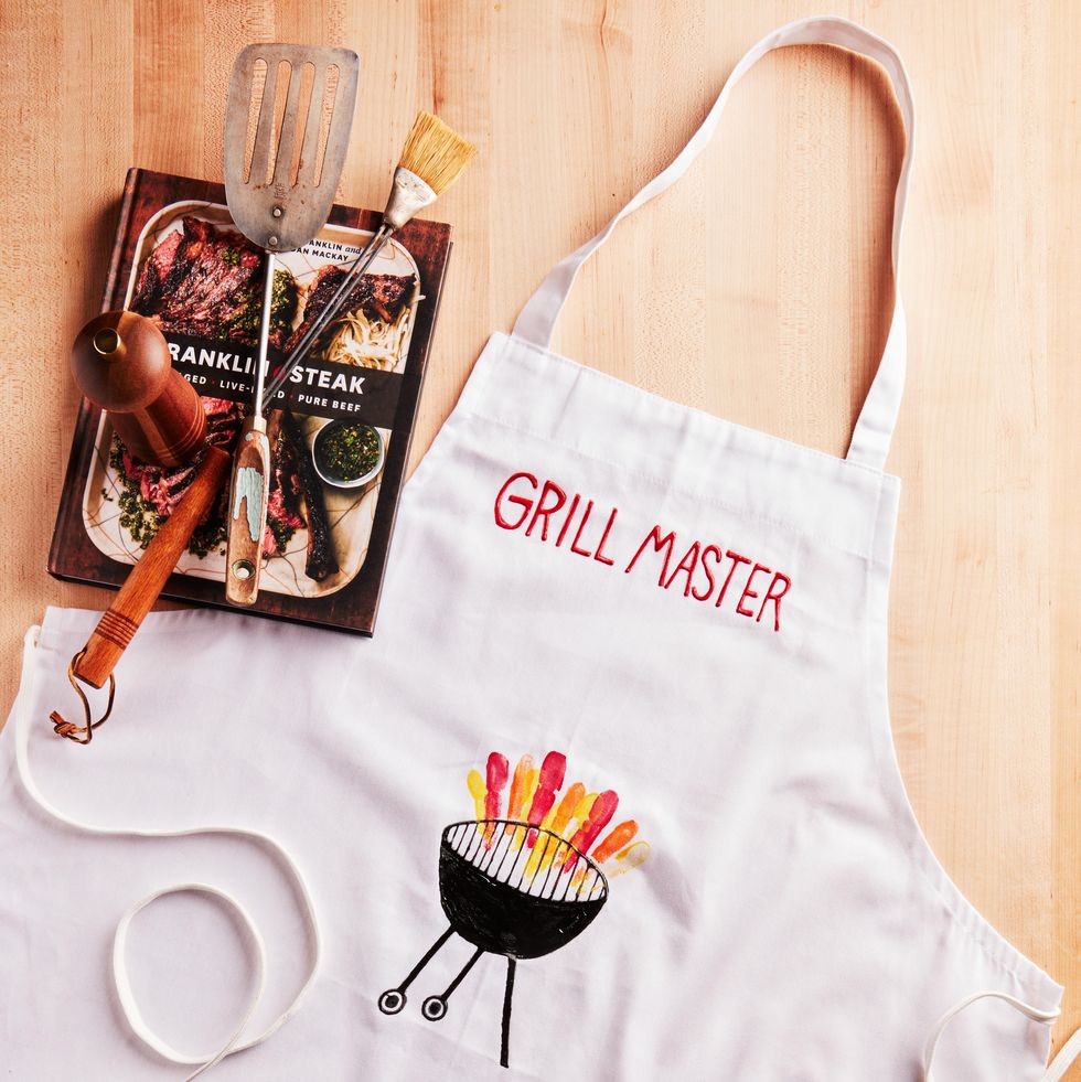 father's day apron decorated with the words grill master and orange and yellow kids finger paint art mimicking grill flames