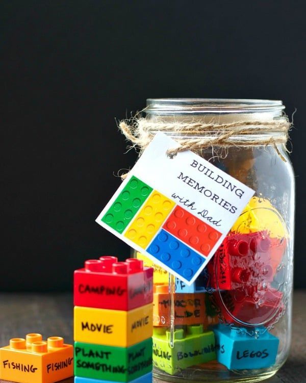 mason jar filled with building blocks labeled with father and child activities such as fishing, hike, movie, camping, bowling, and legos with gift tag reading building memories with dad