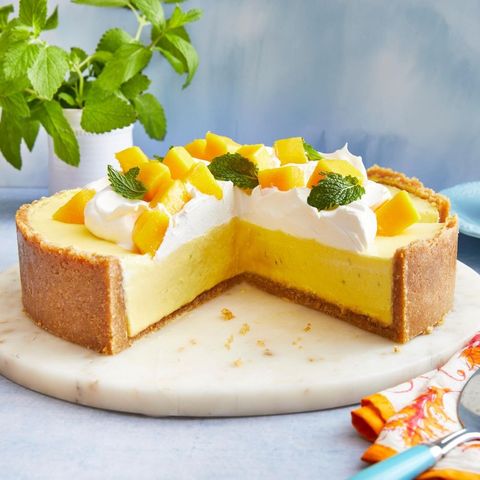 mango cheesecake with whipped cream and mint