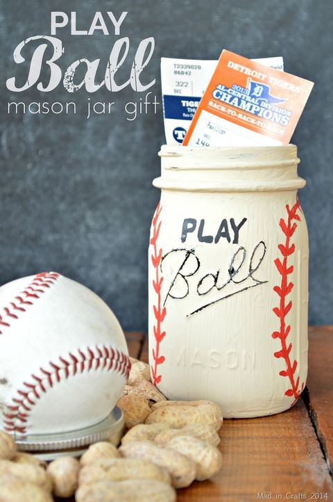 baseball tickets inside a ball jar painted white with red seams to resemble a baseball, with a baseball attached to the lid, and the word play painted above the jar's embossed brand name to read play ball