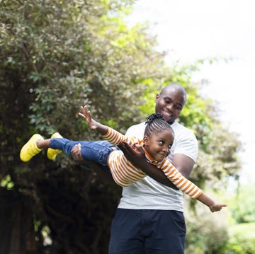 happy little girl flying as father holds her in the air