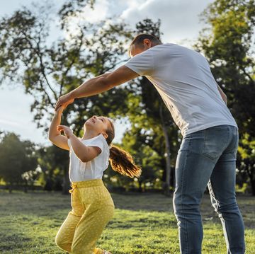 father and daughter playing together in the park